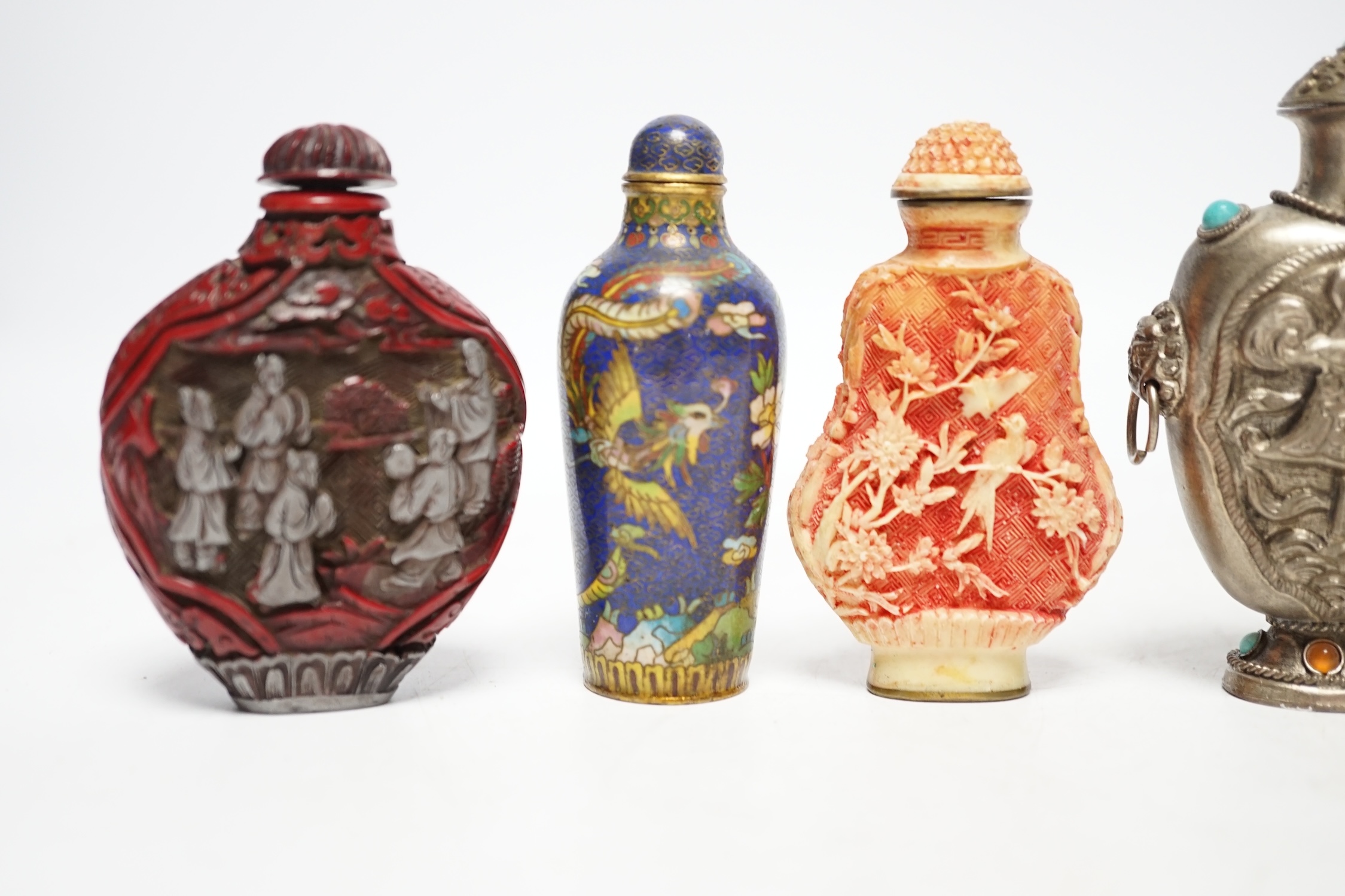 A Chinese cloisonné enamel snuff bottle, two resin snuff bottles, a carved mother of pearl snuff bottle and a Tibetan style metal snuff bottle, largest 8.5cm high